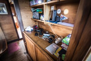 Camera charging station on the wooden counter with housings, cables and chargers