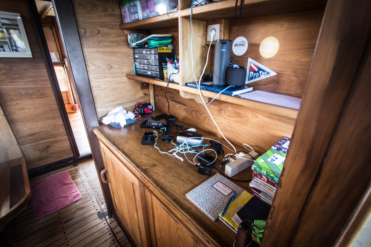 Camera charging station on the wooden counter with housings, cables and chargers