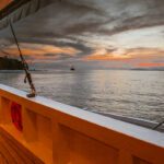 Dusk over a still sea seen past the orange bulwark