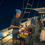 Chef grilling on the open deck after dark