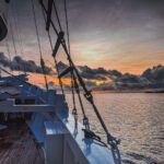 Dusk over the sea seen through the rigging from the deck