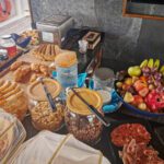Buffet with cereal jars, bread, fruit and charcuterie