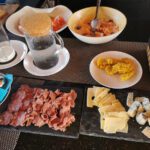 Breakfast table with a cafetiere, ham, cheese and hot dishes