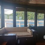 Spa treatment room with a massage bed beside sea-view windows