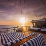 Sun setting beyond the striped daybeds on the top deck