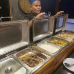 Crew member serving from the hot buffet trays
