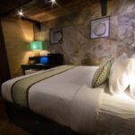 Cabin bed in white linen against a stone-effect wall