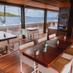 Shaded deck lounge with wooden tables and cushioned seating