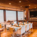 Indoor dining area with white chairs and tables laid for a meal