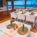 Alfresco tables set with turquoise candles on the dining deck