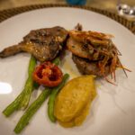 Plated grilled meat and prawn with tomato and vegetables