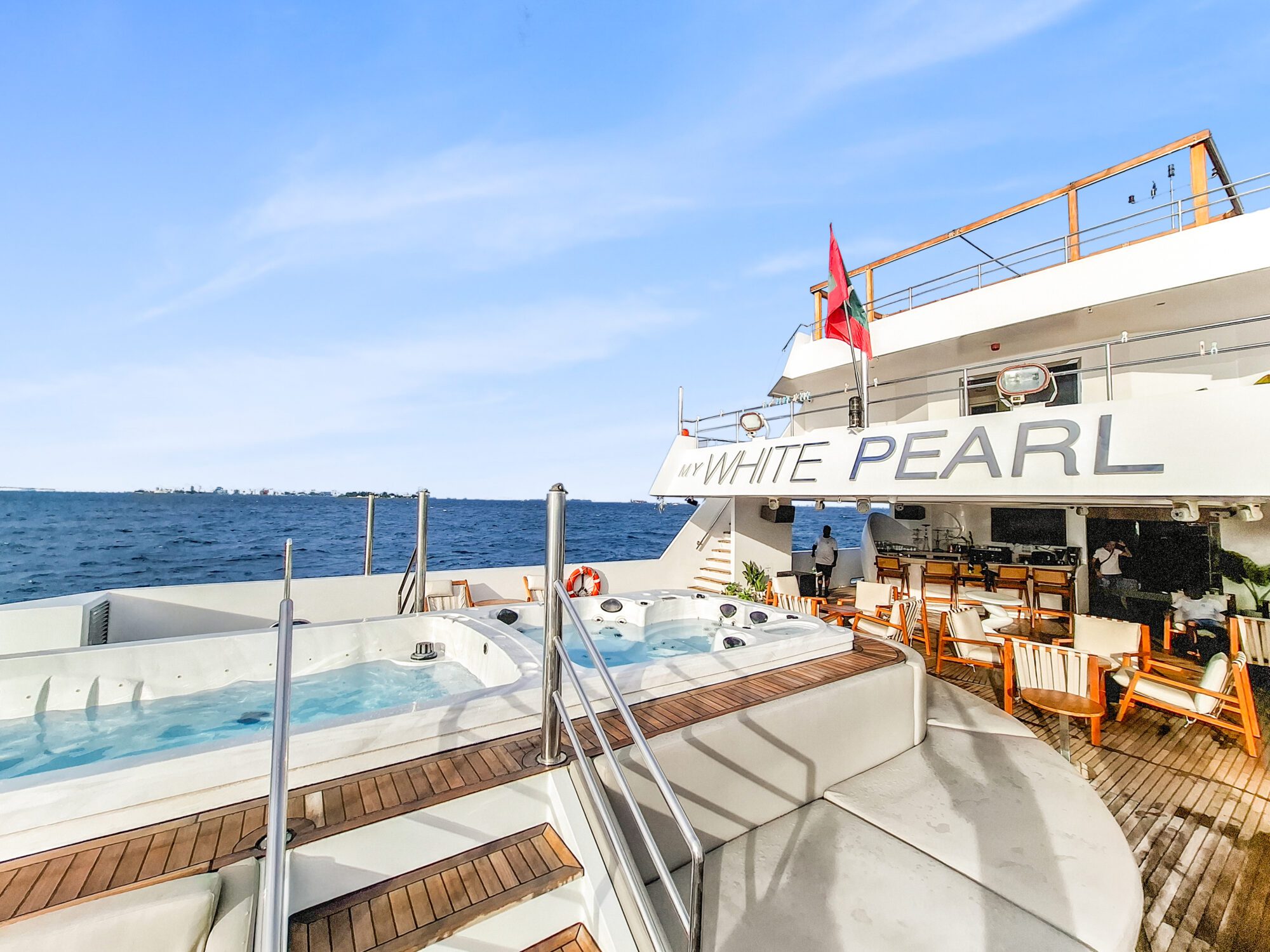 Sun deck of the White Pearl liveaboard with its name on the hull, Maldives
