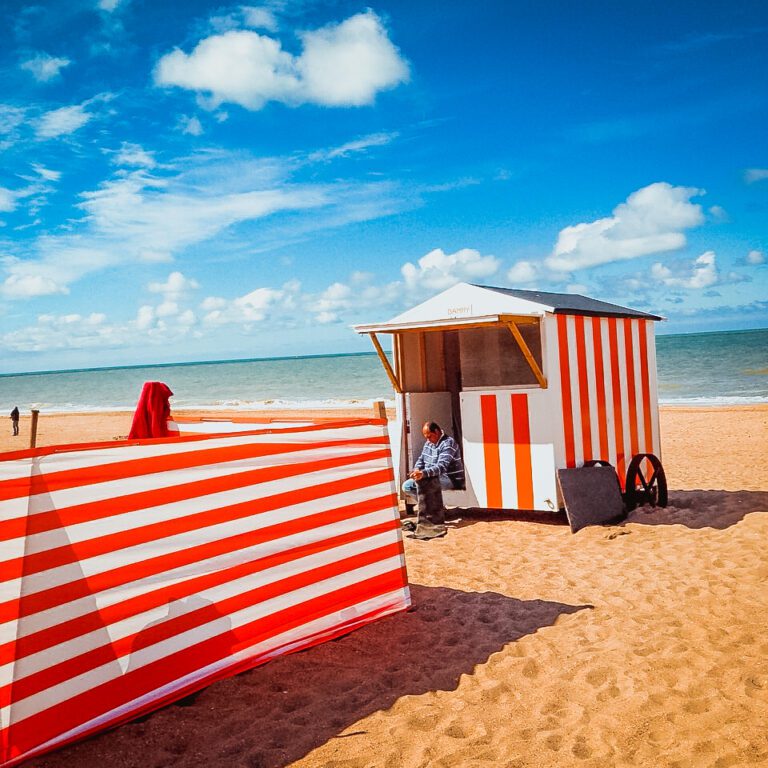The Best Restaurants in De Panne: A Local's Guide After 20 Years of Visits Red-and-white striped beach cabin and windbreak on the sandy beach at De Panne, Belgium