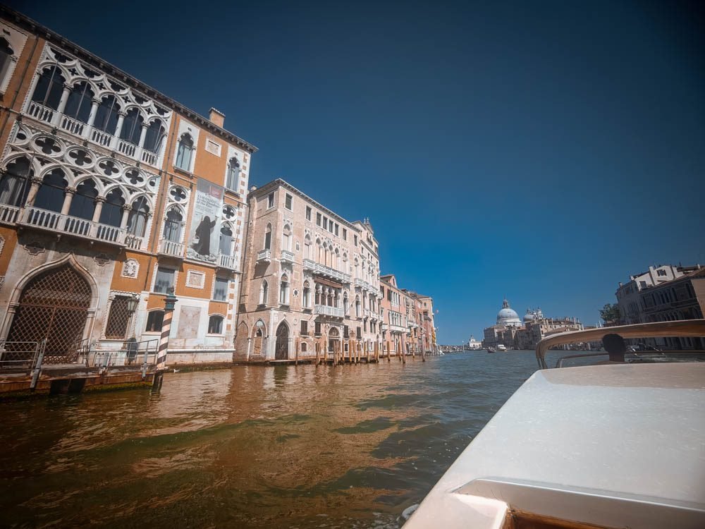 View along the Grand Canal from a Venice water taxi, past palazzo facades towards Santa Maria della Salute