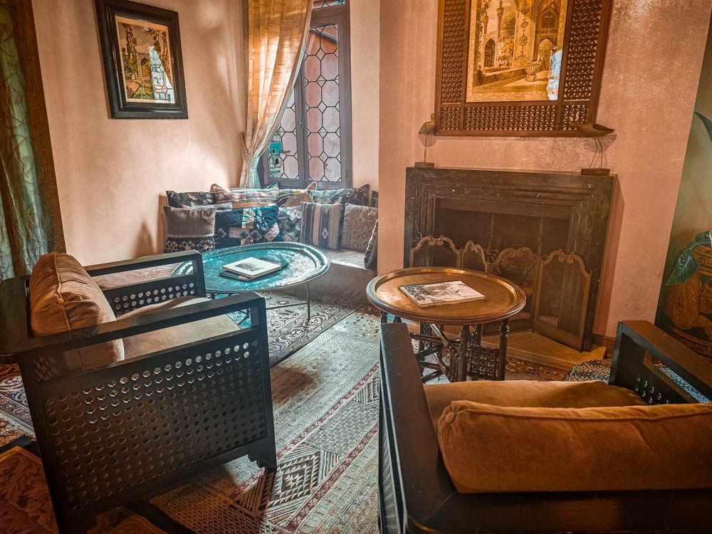 Orientalist sitting area at Novecento Boutique Hotel in Venice, with a carved fireplace, brass tray tables and framed Venetian prints