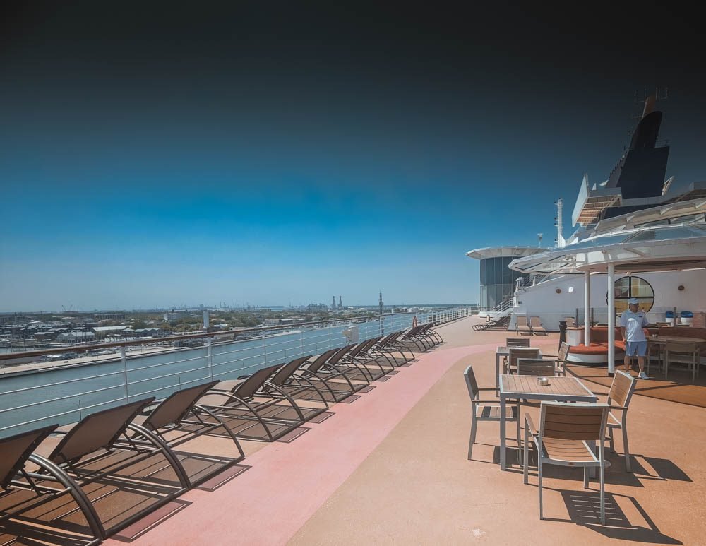 Empty sun loungers on Celebrity Constellation moored at an industrial port