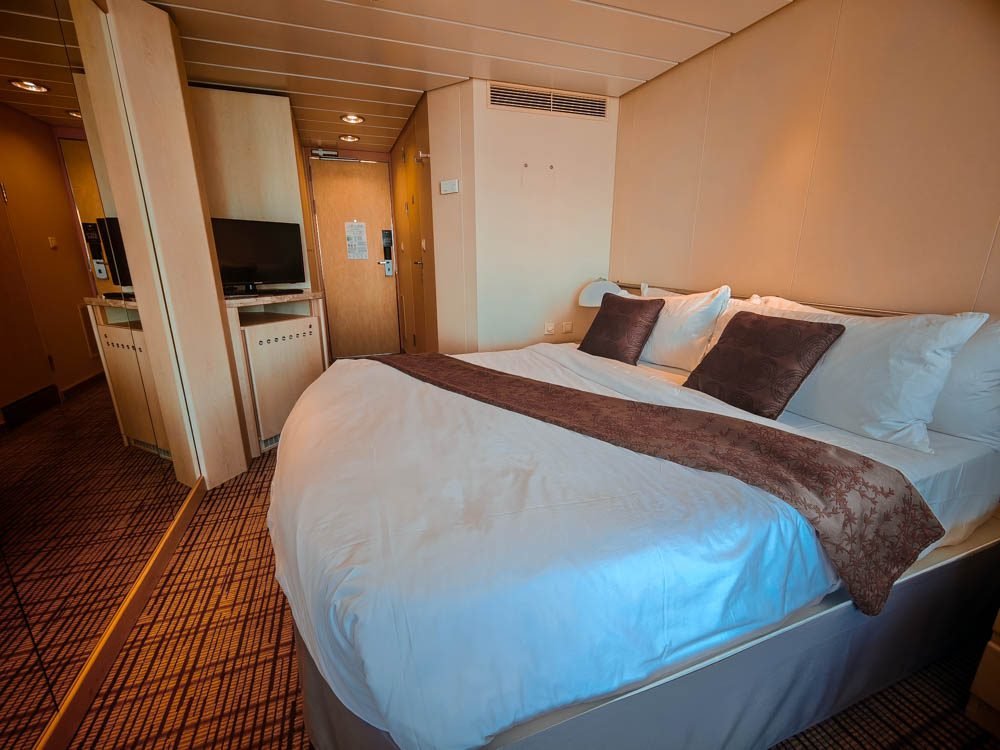 Turned-down bed in an AquaClass balcony cabin on Celebrity Constellation