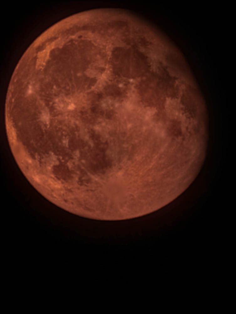 Red moon rising over the sea seen from Celebrity Constellation