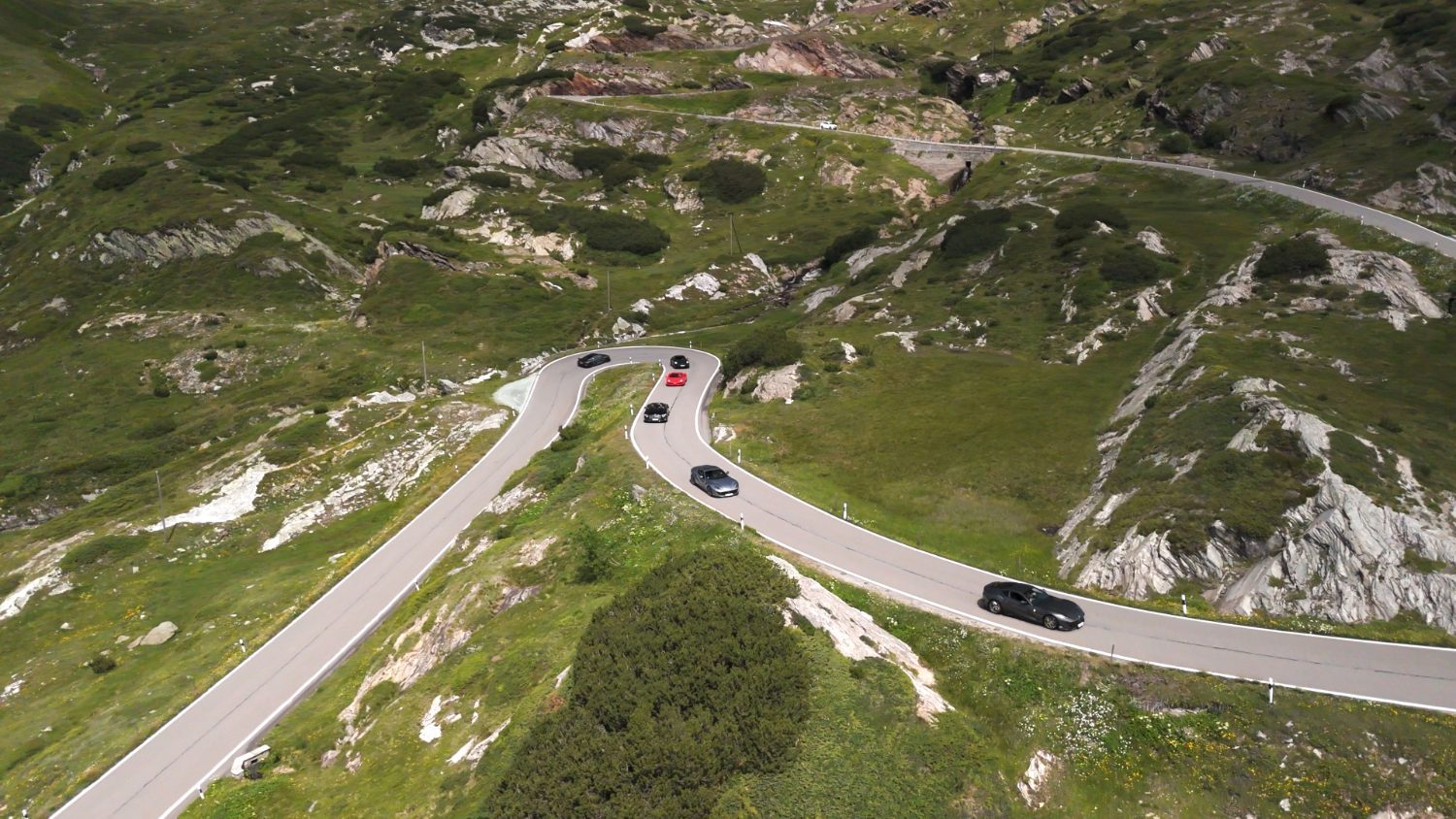 A winding Alpine pass road during a drive in motion supercar tour through Switzerland