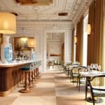 Two Lisbon Palaces, One 1,000 sqm Spa: Six Senses Bets Big on the City Six Senses Lisbon restaurant with tall windows, stone bar and pendant lighting inside the Palacio Lavra