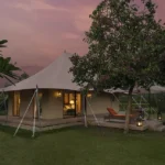 Oberoi Bets 19 Tents on the Best Tiger Odds on Earth Luxury tent lit at dusk with its private deck at The Oberoi Vindhyavilas Wildlife Resort, Bandhavgarh