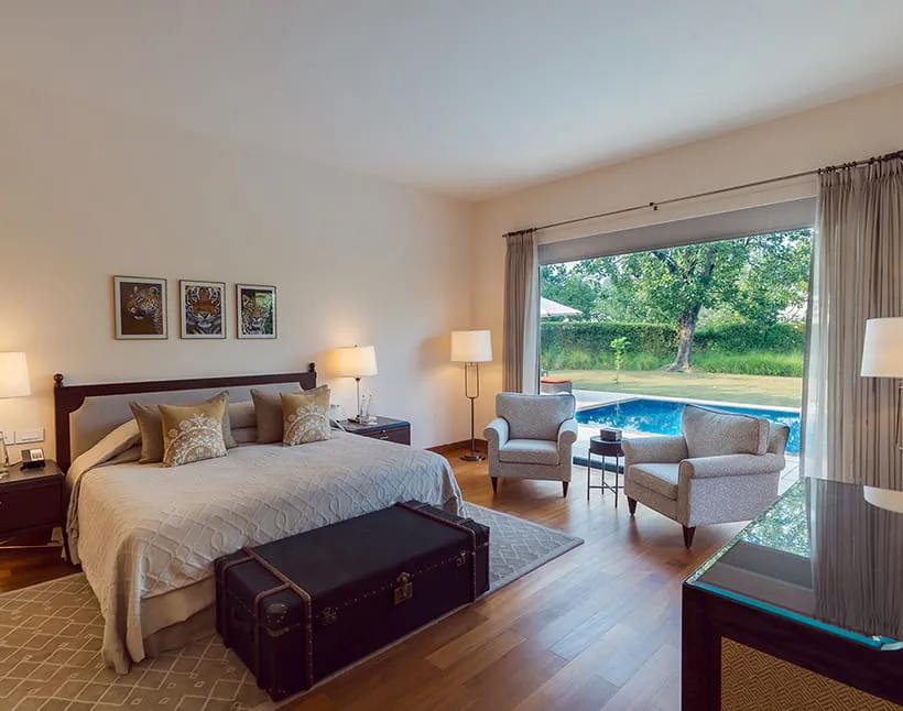 Luxury Villa bedroom with hand-painted wildlife studies and a private pool view at The Oberoi Vindhyavilas Bandhavgarh