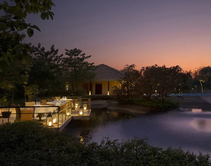 The Bush Kitchen lakeside dining setting at The Oberoi Vindhyavilas Wildlife Resort, Bandhavgarh