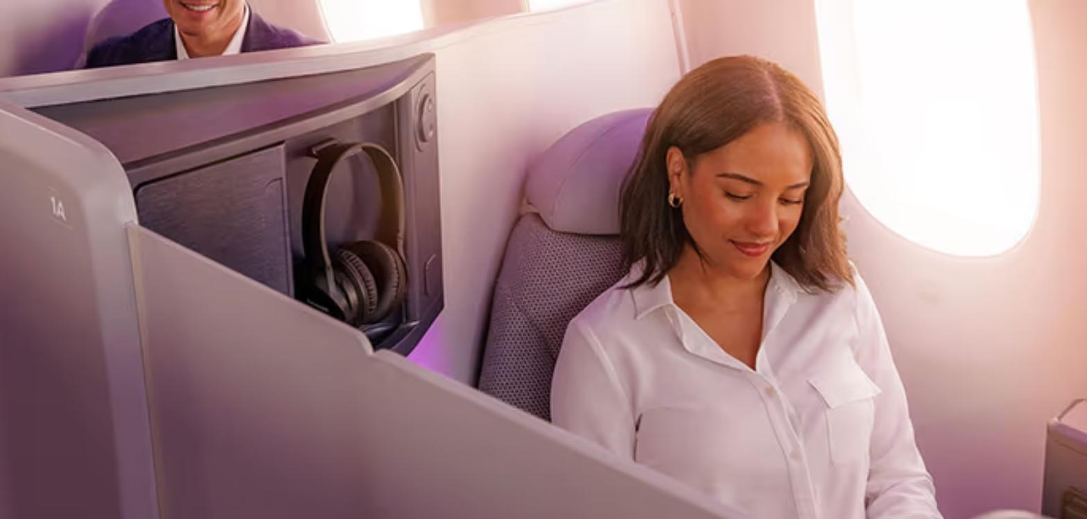 Passenger seated in Air New Zealand Business Premier Luxe with the privacy door closed beside her
