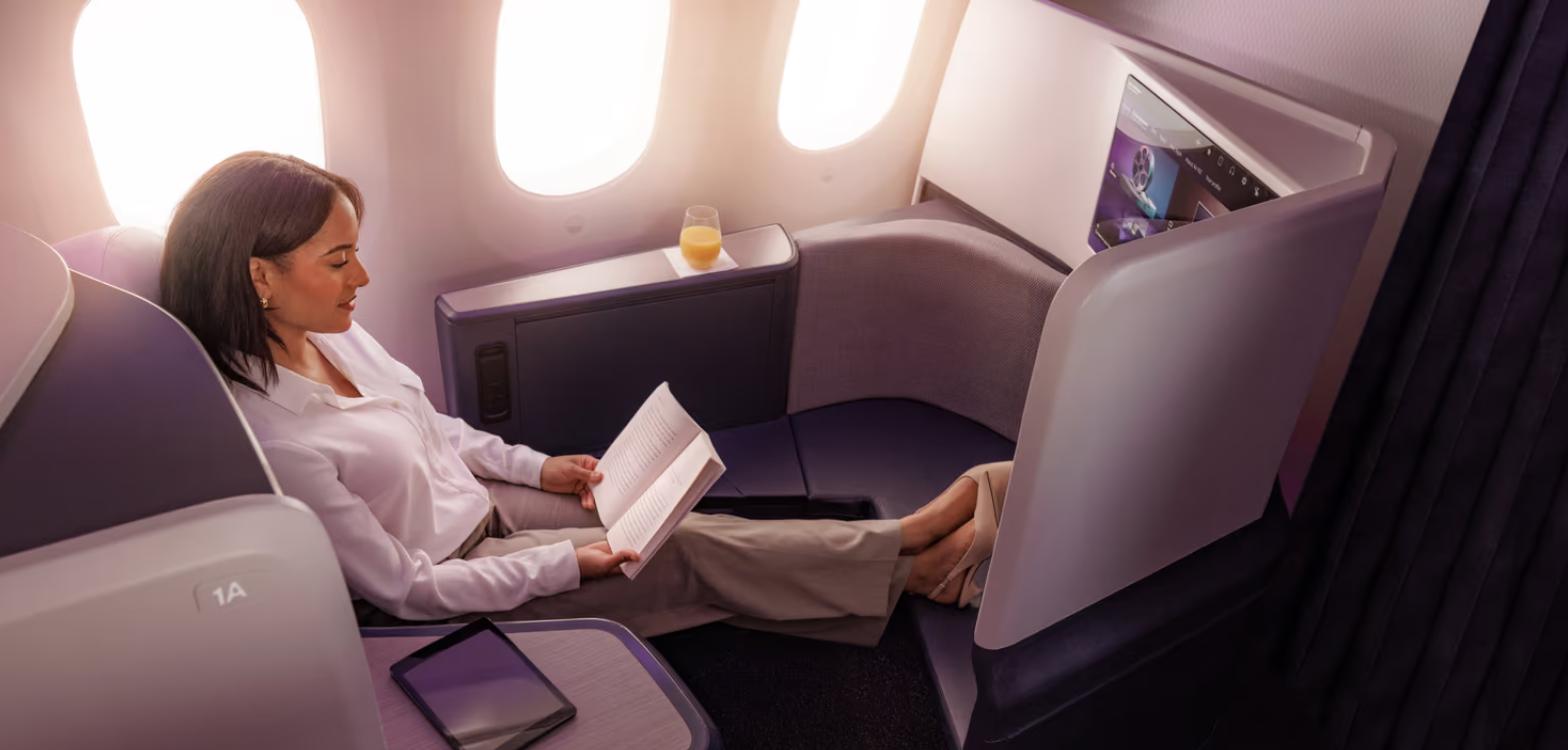 Passenger reading in an Air New Zealand Business Premier Luxe seat beside the 787 windows