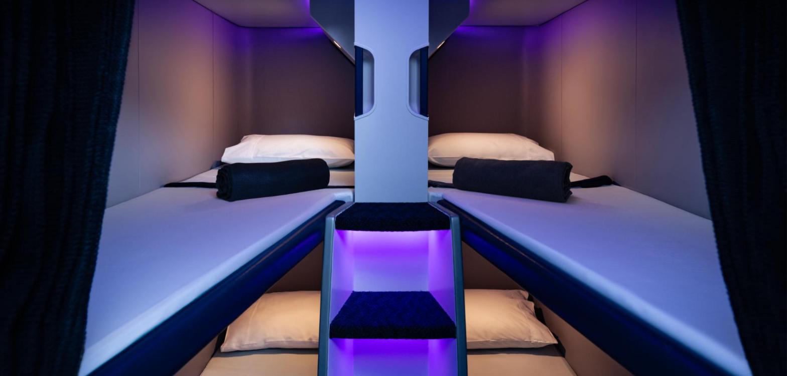 Interior of the Air New Zealand Economy Skynest showing stacked bunks made up with pillows and blankets