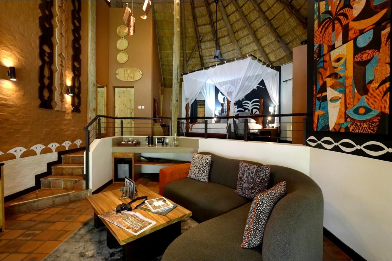 The split-level lounge and canopied bed inside a villa at Albida - Victoria Falls