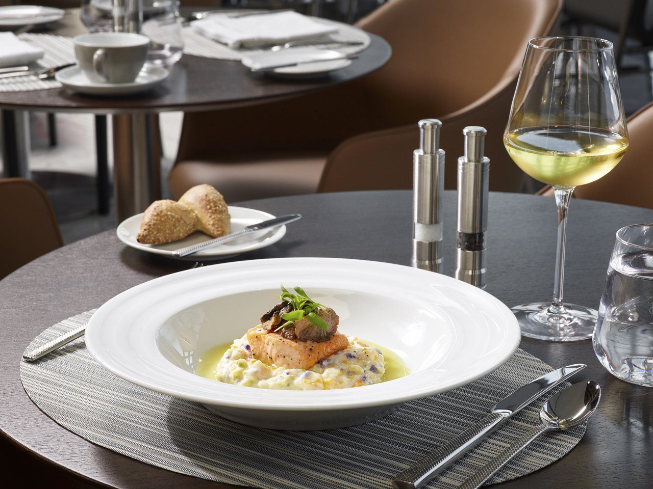 Plated salmon dish served with wine in American Airlines Flagship Dining