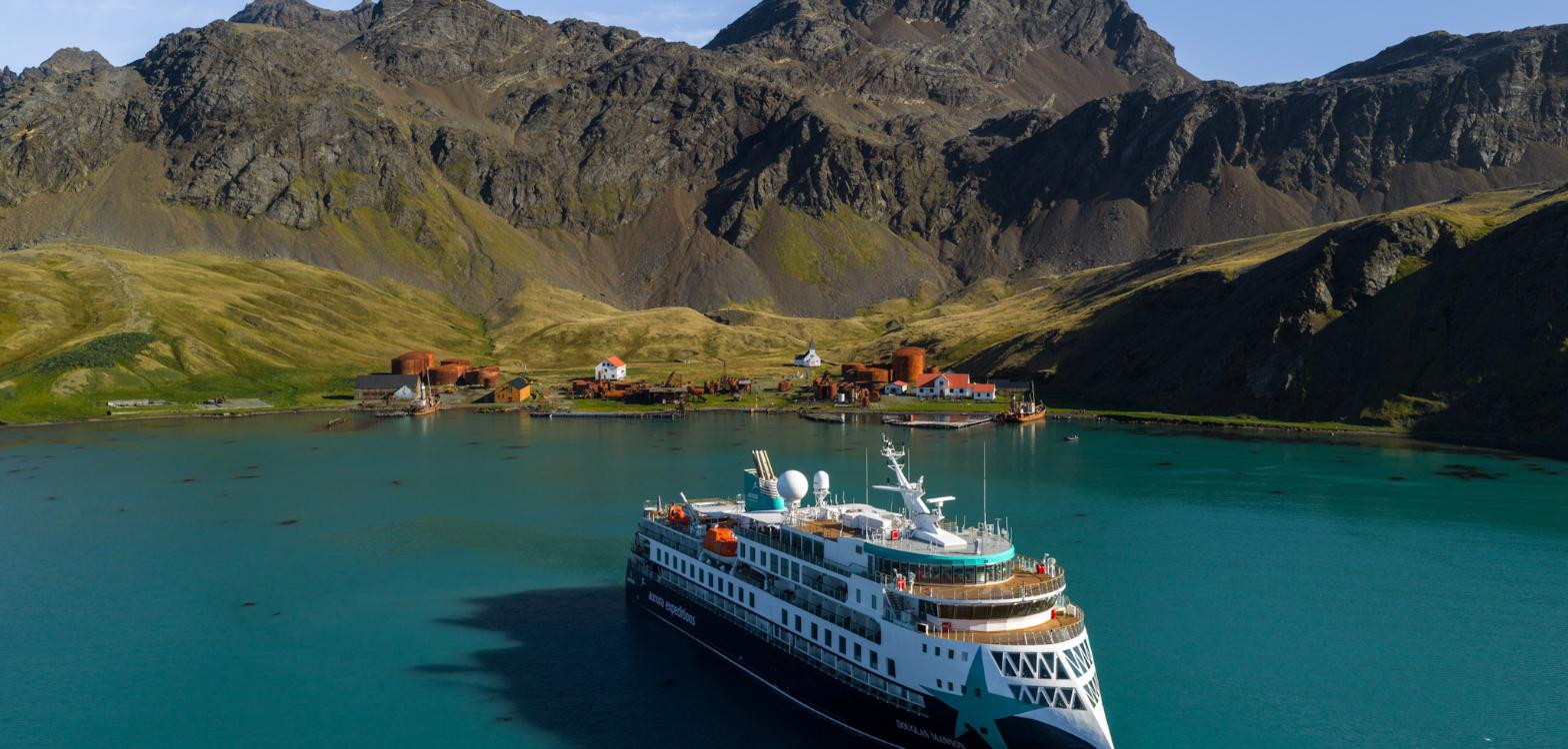 AE Expeditions’ Douglas Mawson at anchor in turquoise water off the old whaling station at Grytviken, South Georgia