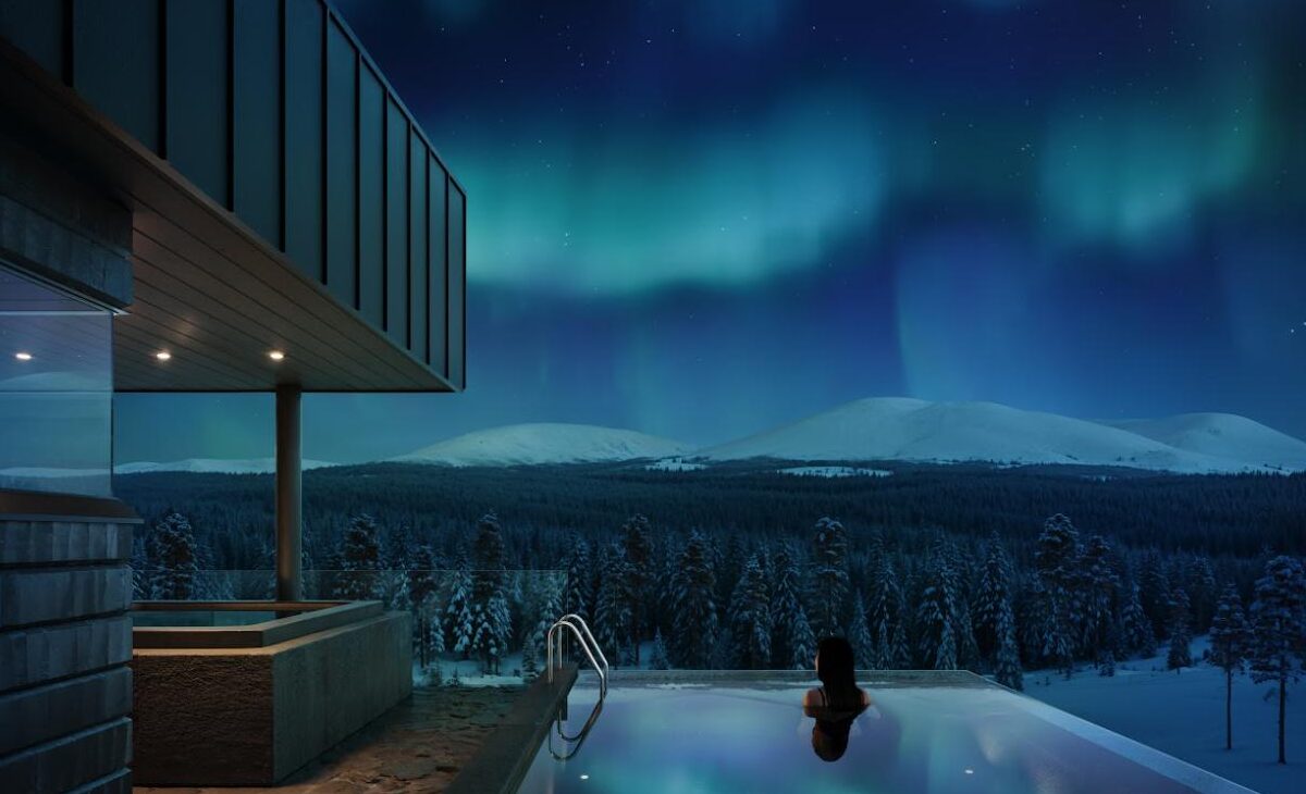 Heated rooftop infinity pool at Arcora Boutique Hotel & Villas with a swimmer beneath the aurora borealis
