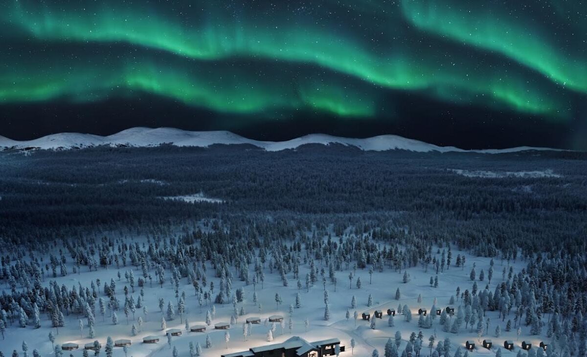 Aerial view of Arcora Boutique Hotel & Villas beside Torassieppi lake under the northern lights