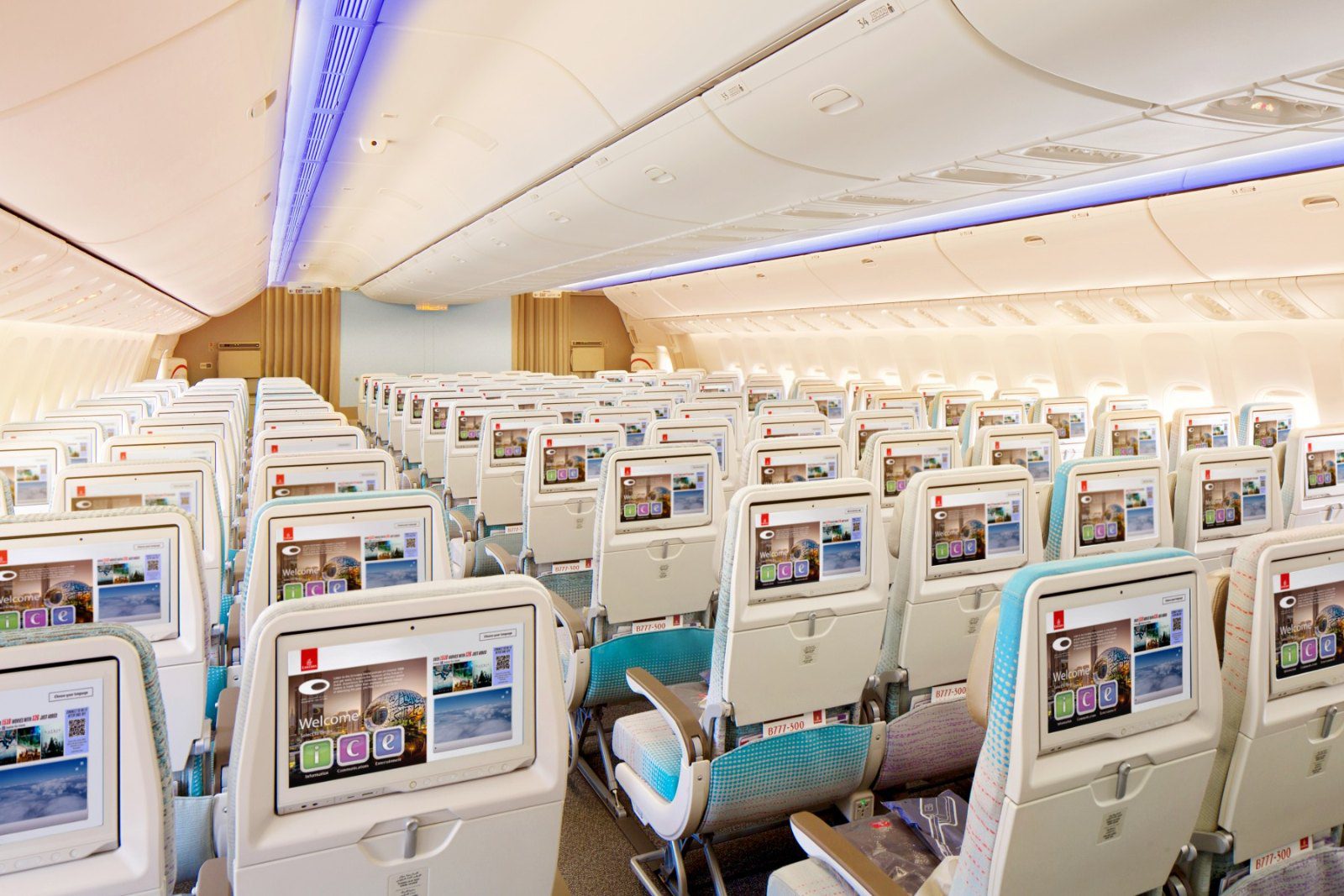 Economy Class cabin of an Emirates Boeing 777-300ER with seat-back screens and mood lighting