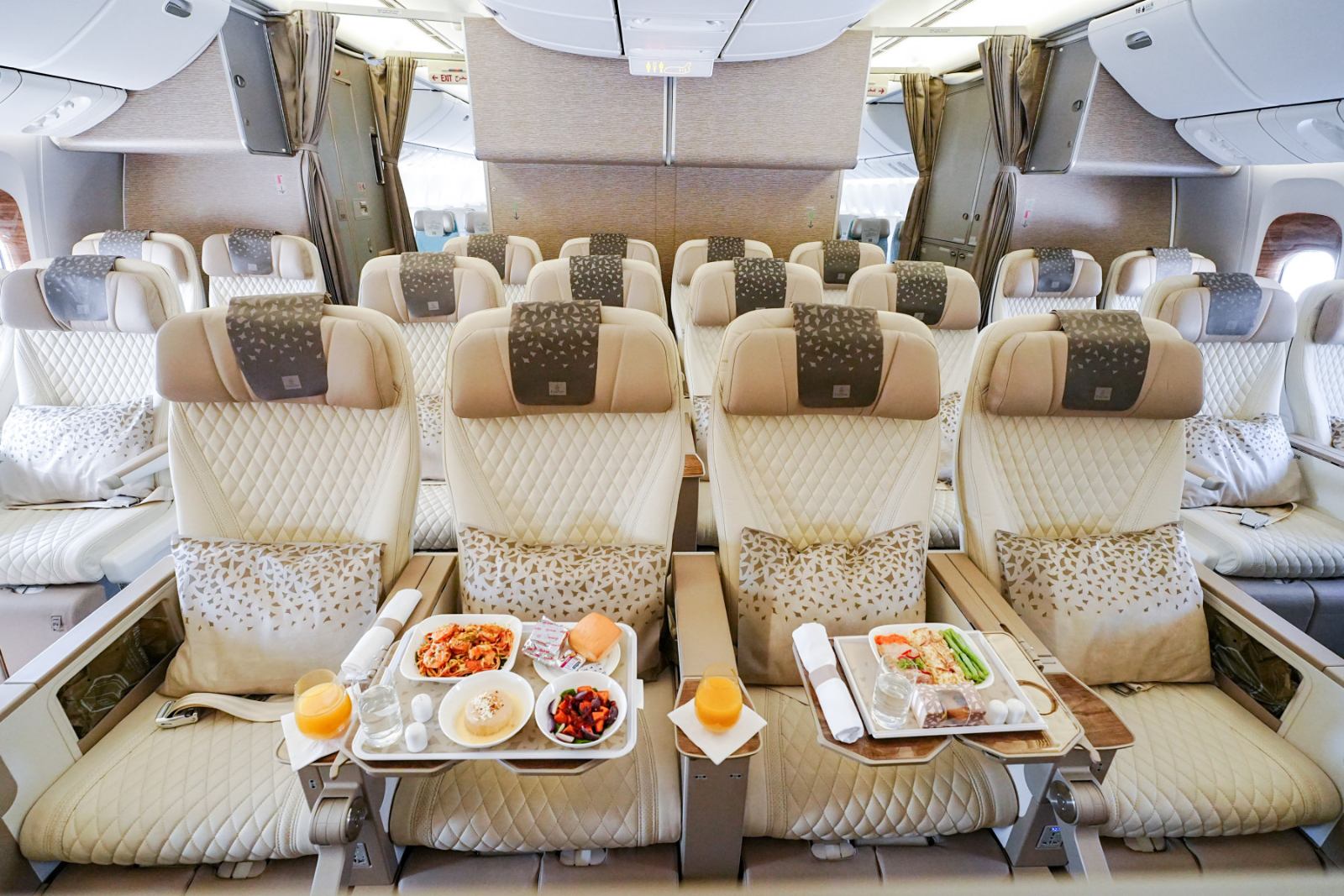 Emirates Premium Economy cabin on a retrofitted Boeing 777 with meal trays set on the tables
