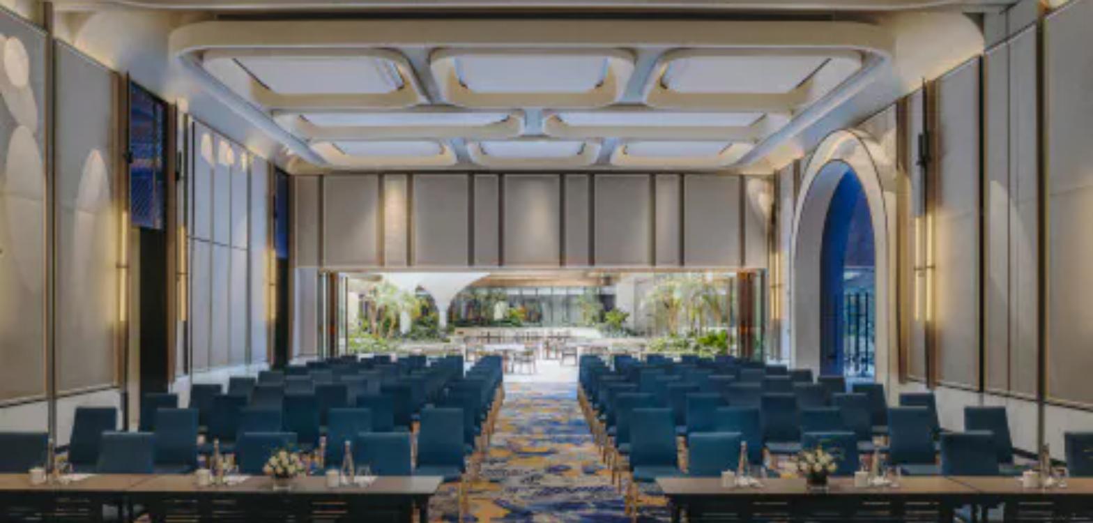 A junior ballroom at Fairmont Hanoi set theatre-style beneath a sculpted coffered ceiling