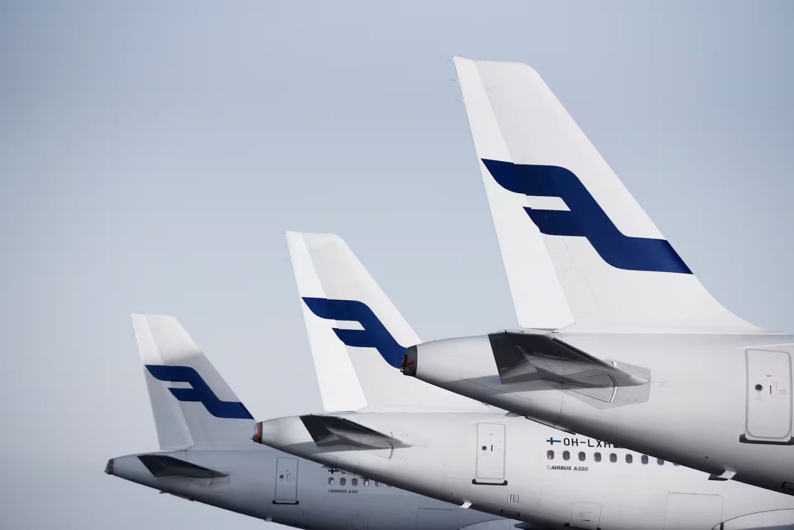 Tails of three Finnair aircraft in the airline's blue-and-white livery