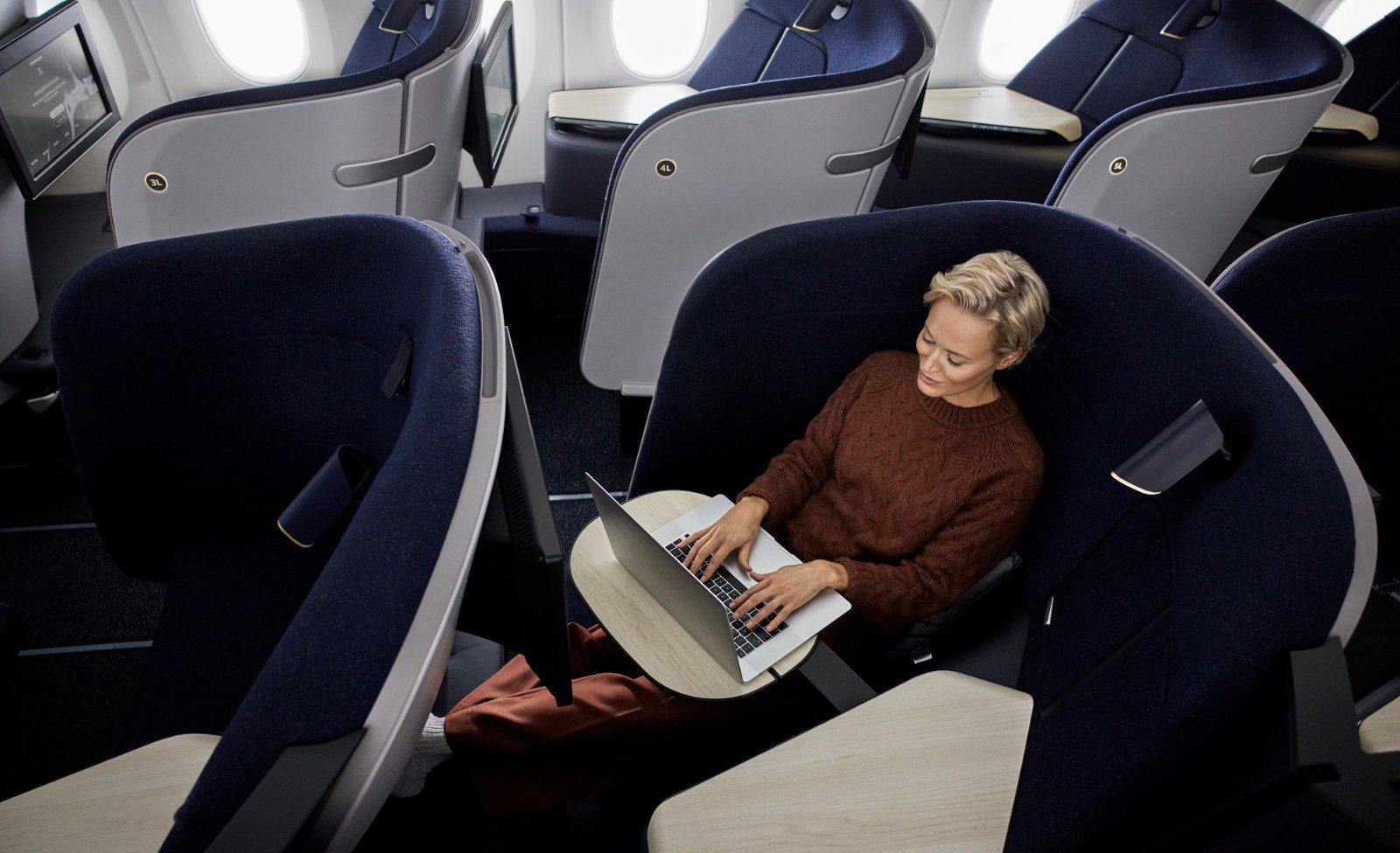 Passenger working on a laptop in a Finnair AirLounge business class seat