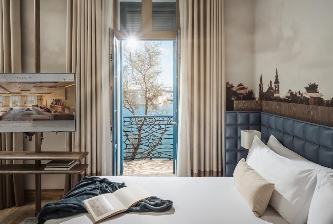 Superior Grand Harbour View Suite at Iniala Valletta, with French doors opening onto a harbour-facing balcony