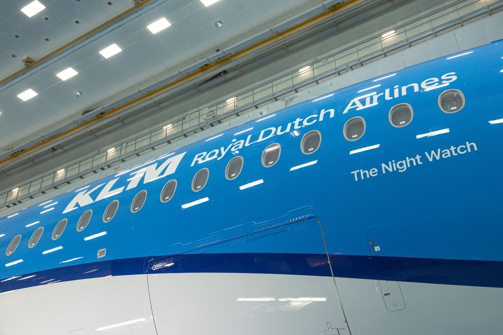 Side of KLM’s first Airbus A350-900 in the paint hangar showing the KLM Royal Dutch Airlines titles and the name The Night Watch