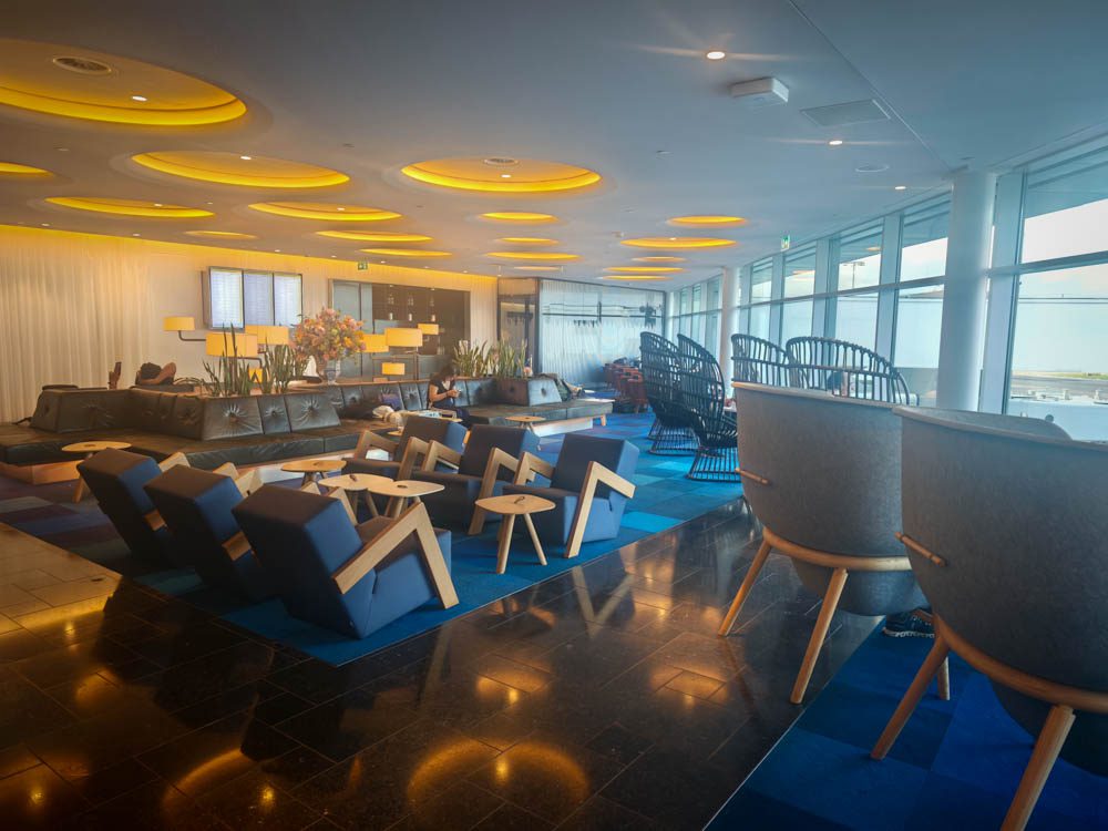 Spacious seating area with armchairs and tarmac views at KLM Crown Lounge 52, Amsterdam Airport