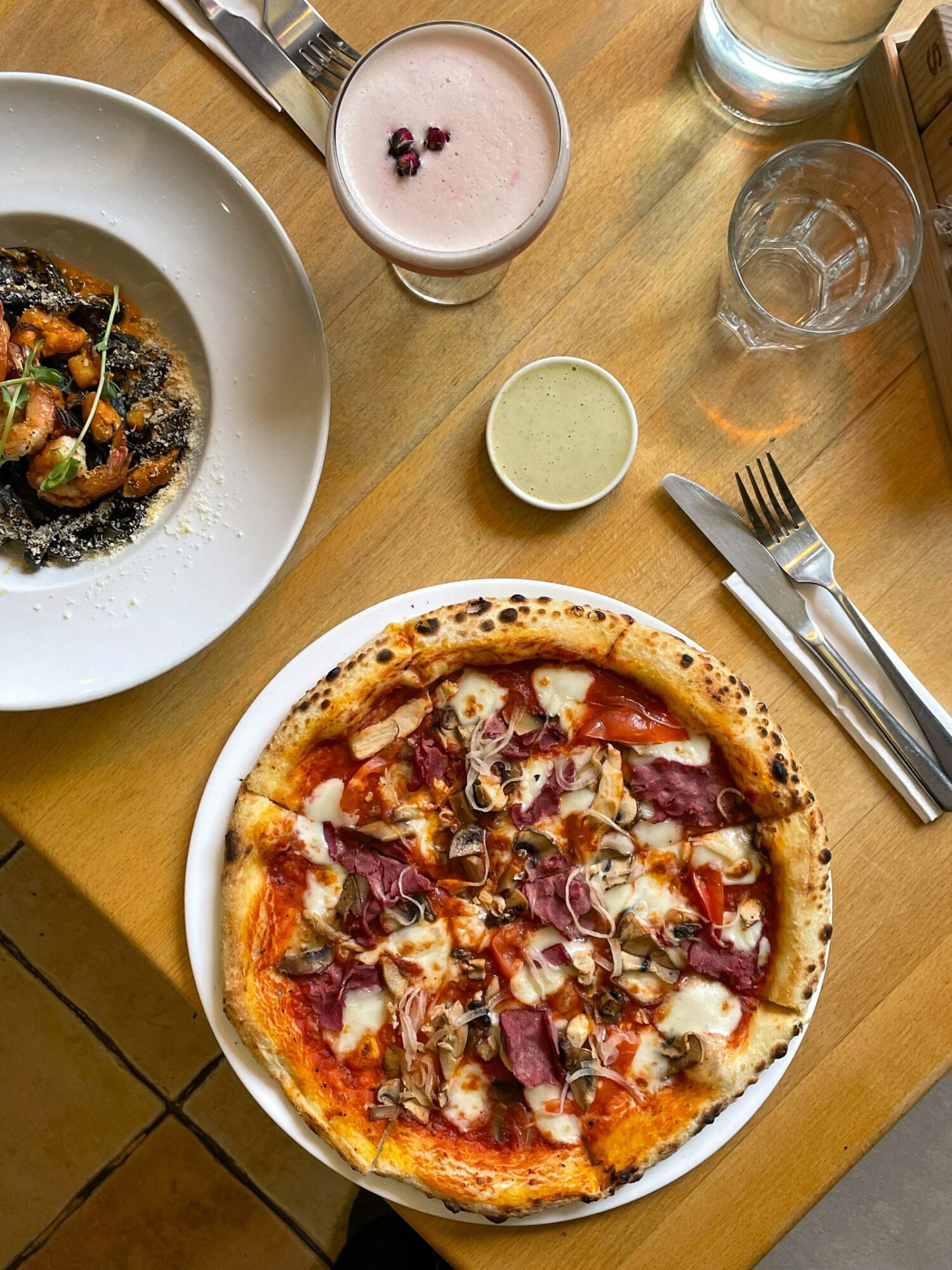 Table set with pizza and shared plates at a casual restaurant