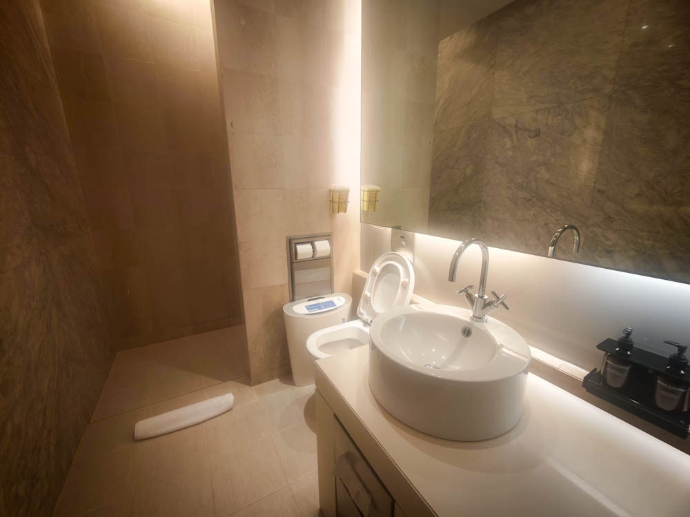 Marble shower suite with toilet and sink at the Qantas Business Lounge, Singapore Changi