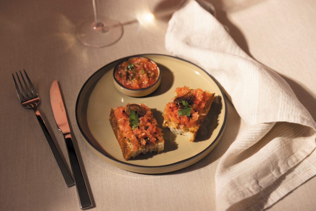 Pan con tomate, one of the tapas on the Solmar Terrace menu from Regent Seven Seas Cruises, plated on a cream dish
