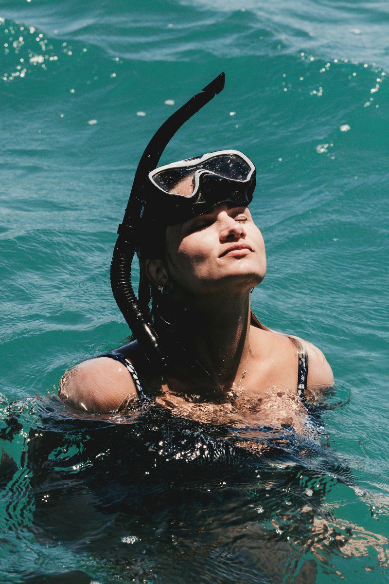 Snorkeller floating at the sea surface wearing a traditional mask and snorkel