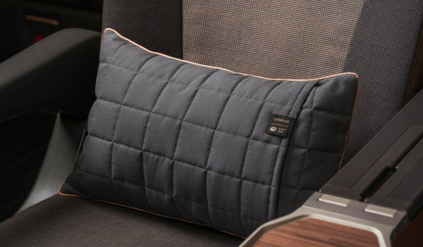 Quilted STARLUX long-haul pillow resting on a cabin seat