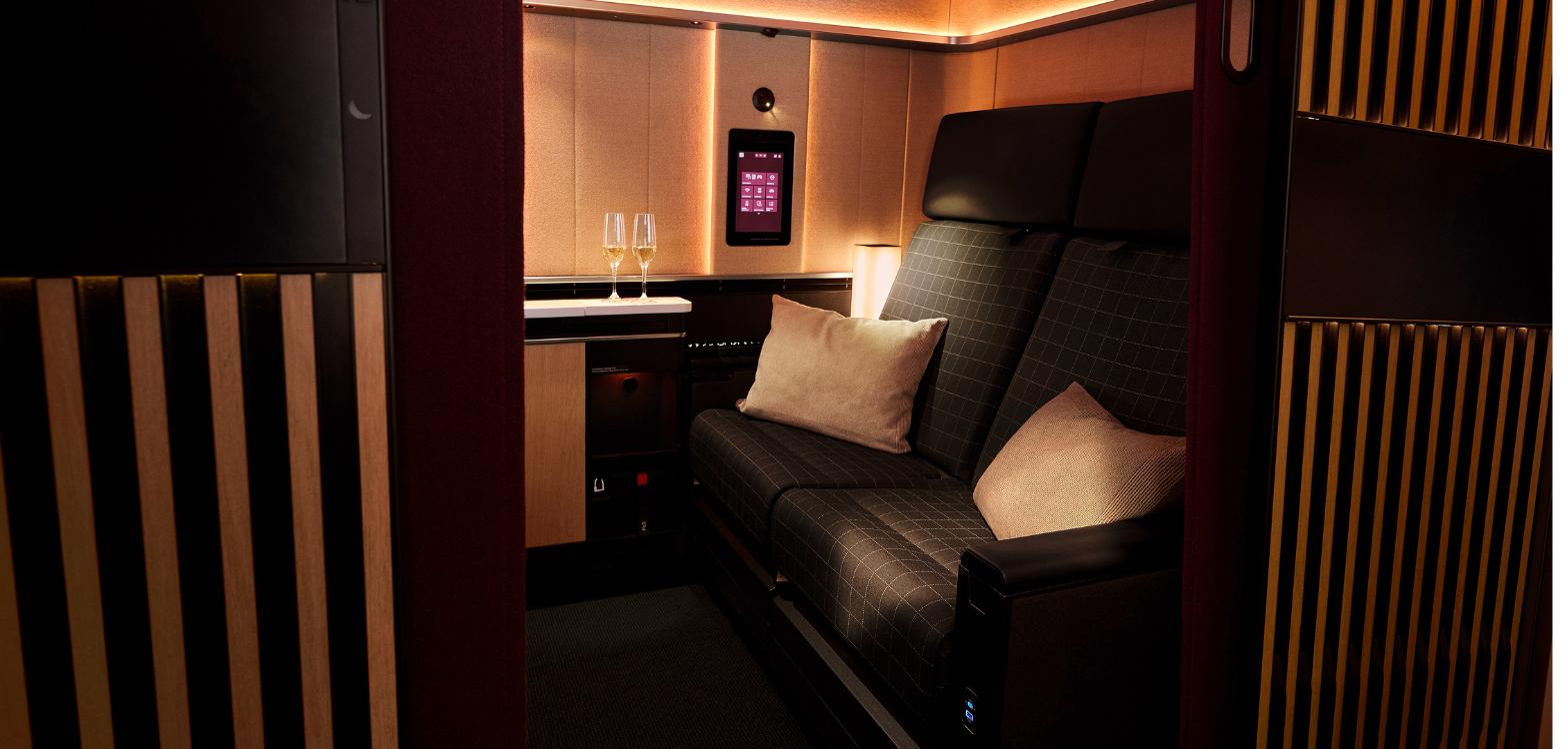 The double seat in the SWISS Senses First Suite Plus with two glasses of champagne on the ledge