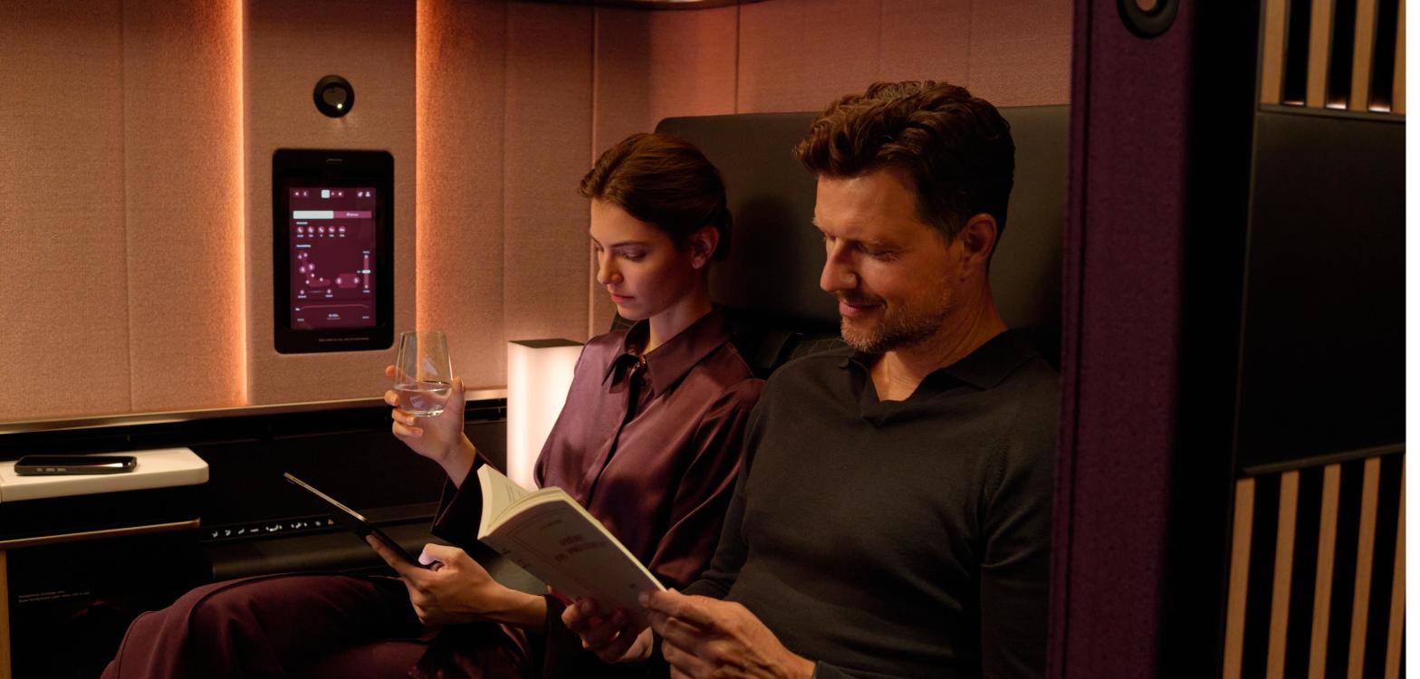 Two passengers sitting together in the SWISS Senses First Class Suite Plus with the sliding door closed